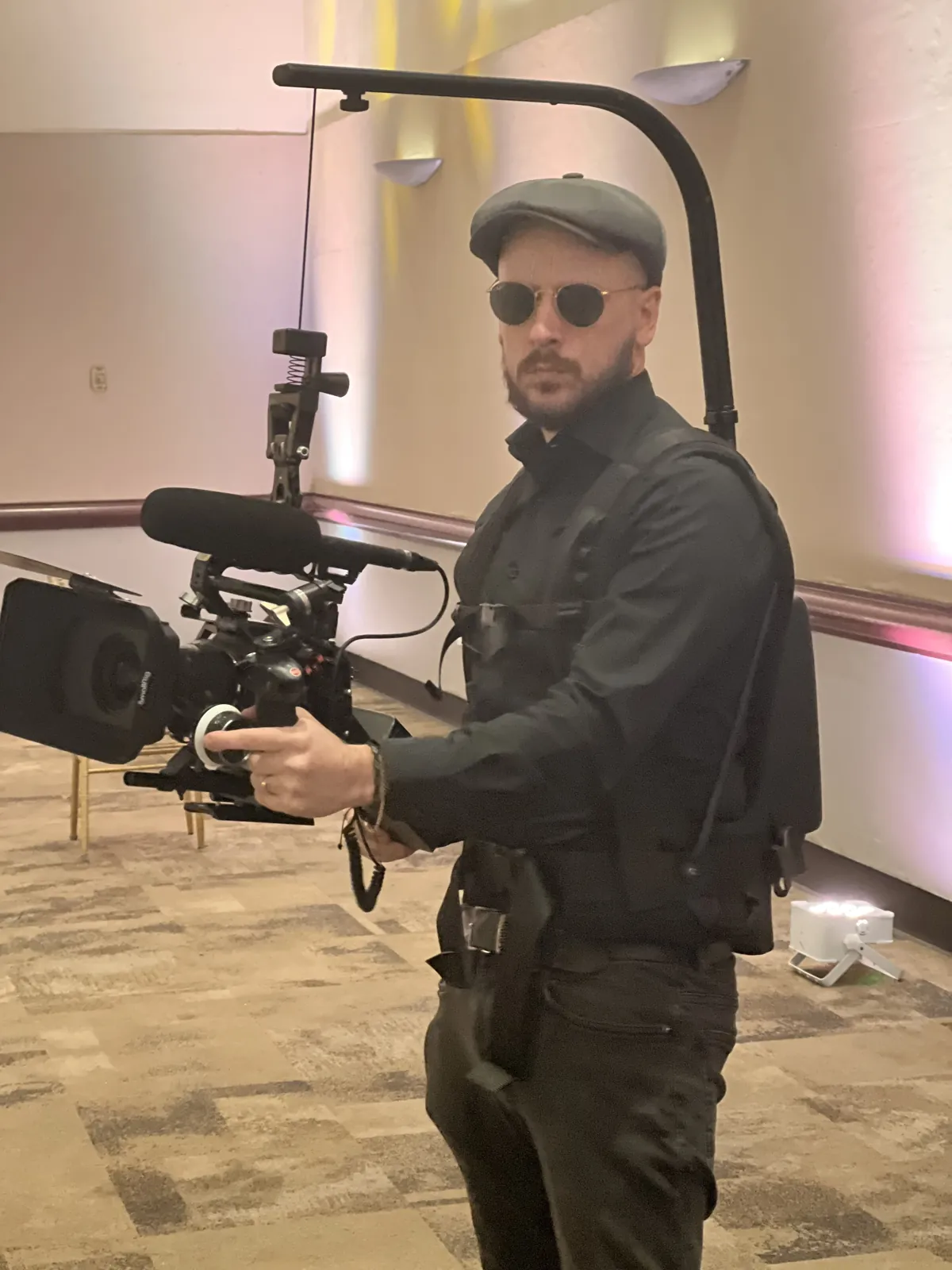 Federico filming with a cinema camera rig at a wedding.