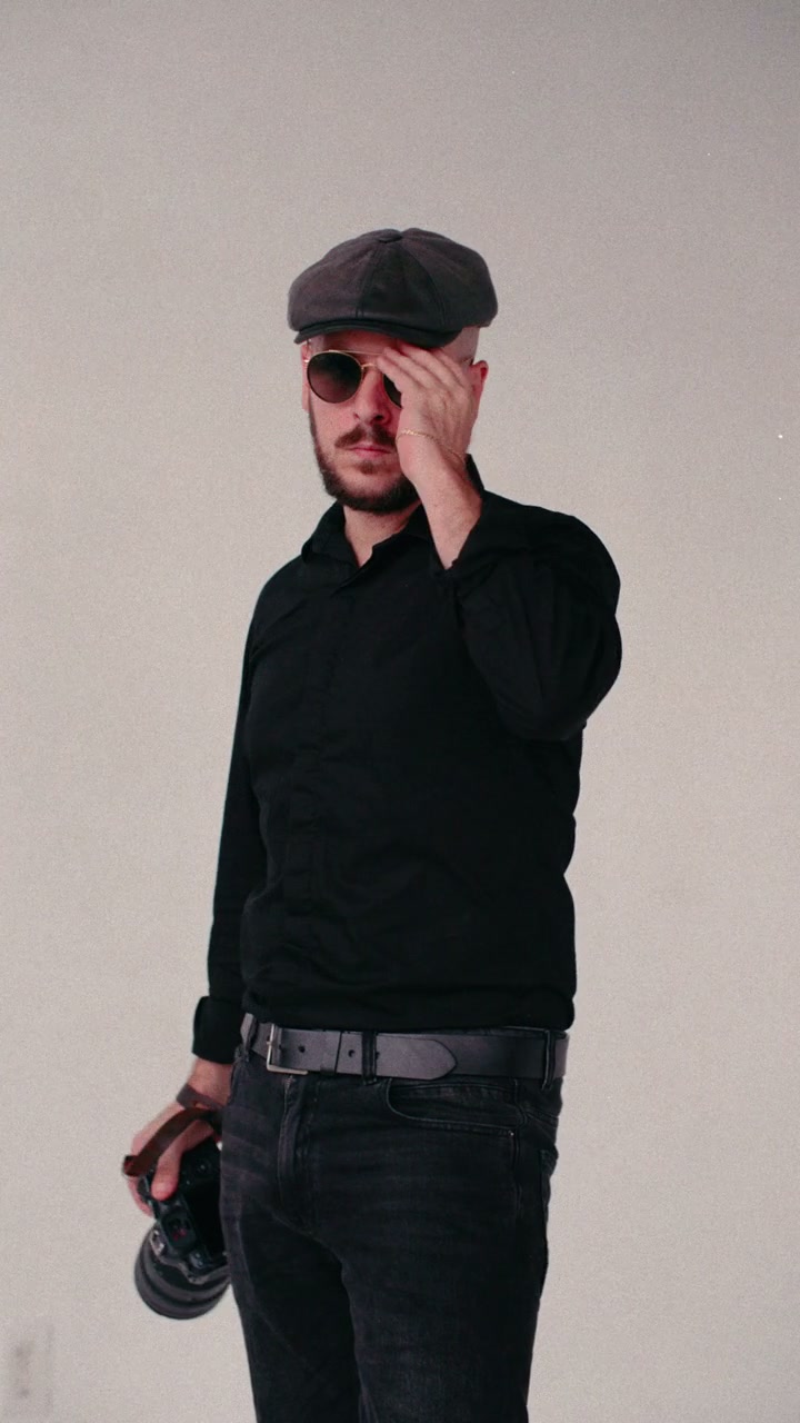 Federico Alessandro Galli holding his camera, wearing a cap and sunglasses.