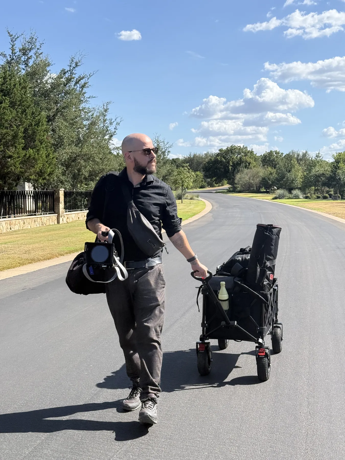 Federico with camera bags on a sunlit Texas road, on the way to a wedding.