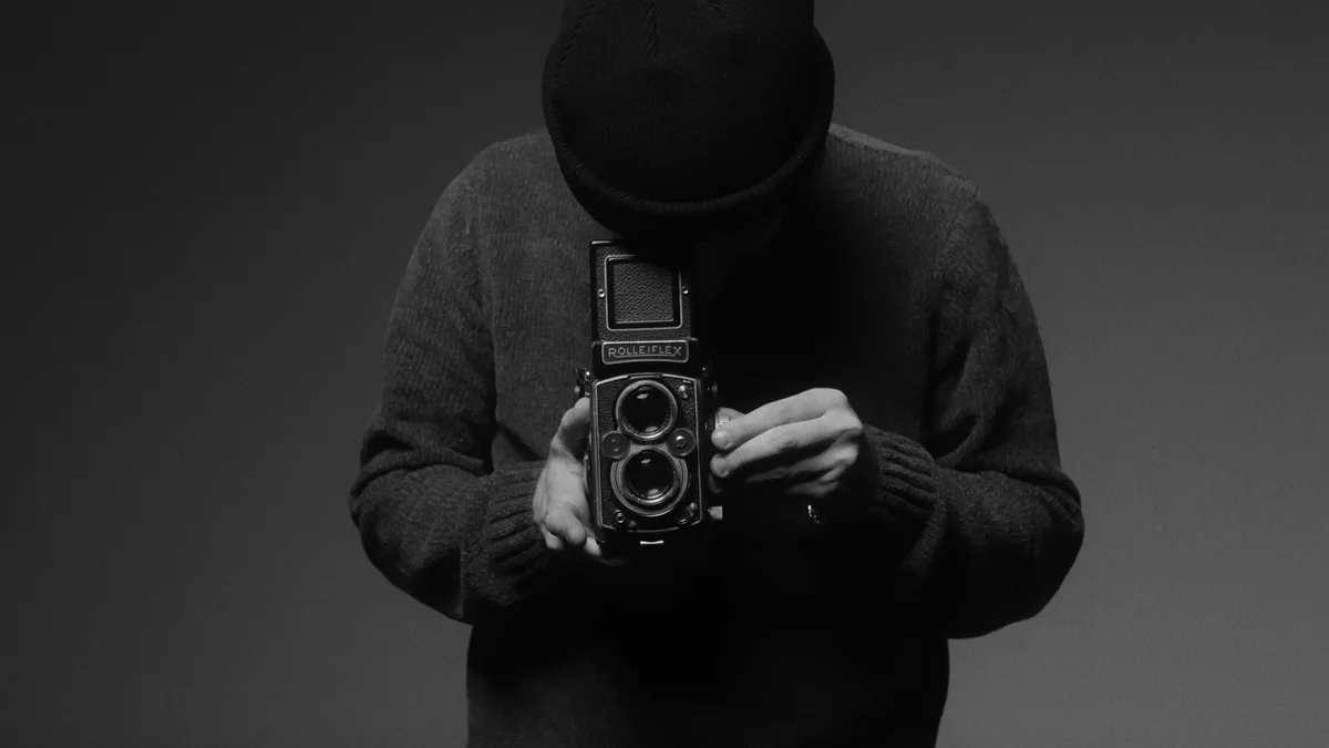 Federico looking into the waist-level viewfinder of his Rolleiflex in the studio.