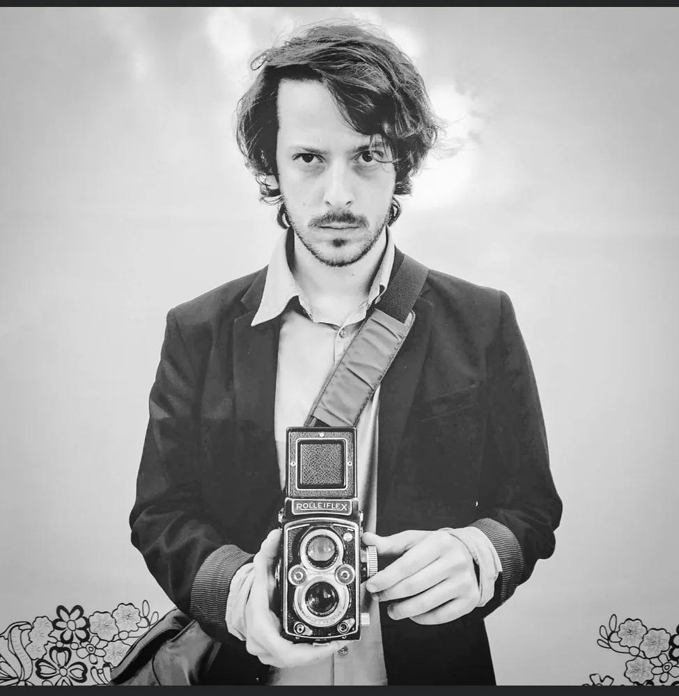 Black-and-white portrait of Federico holding his Rolleiflex.