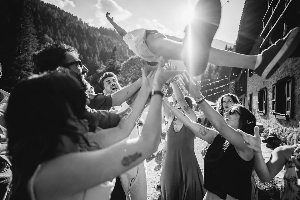 The bride lifted into the air by celebrating guests.