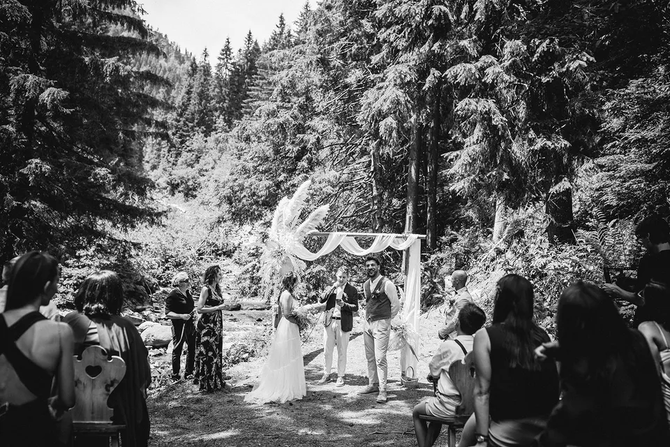 An outdoor wedding ceremony in black and white.